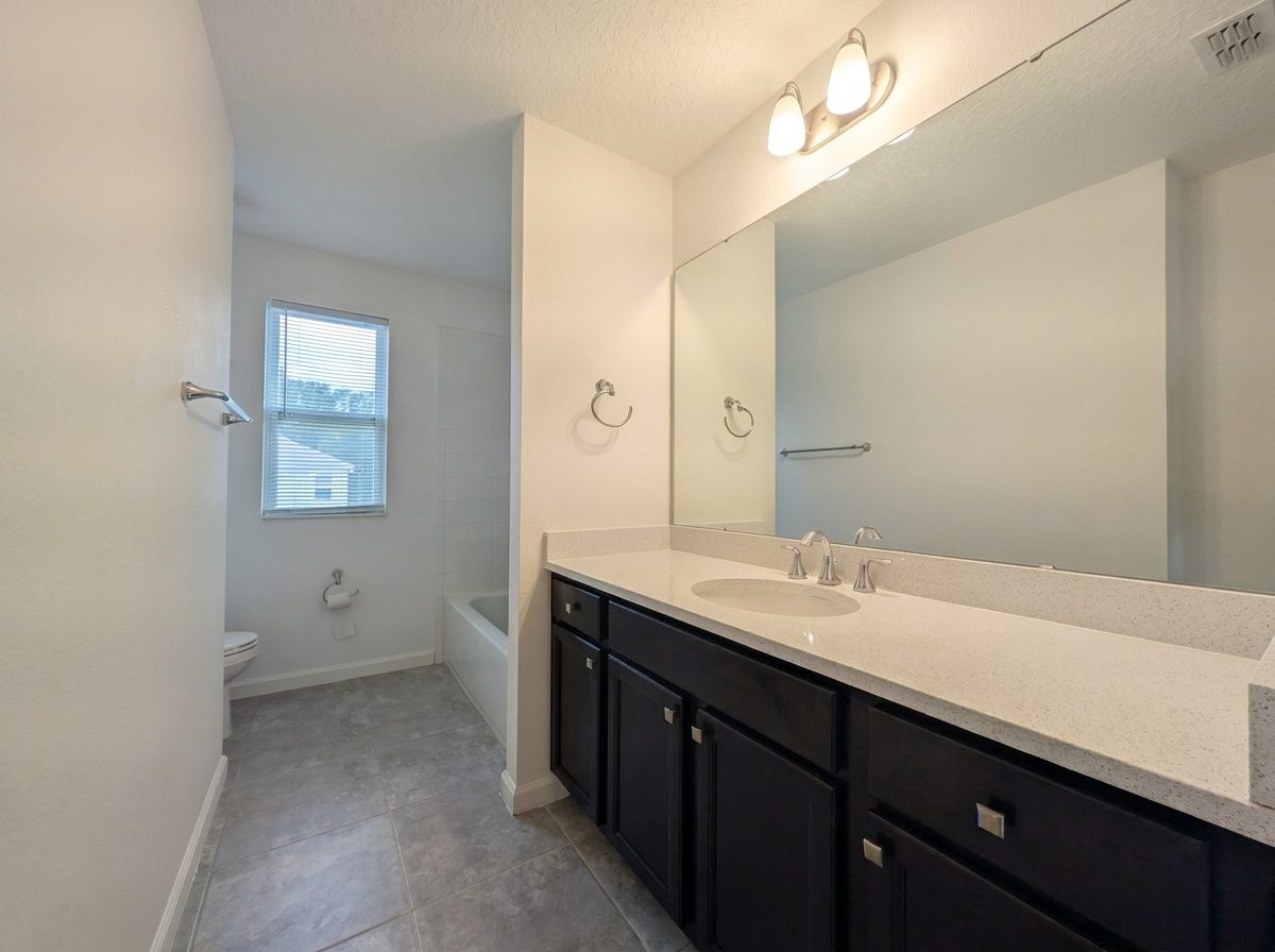 Bathroom with a dual-sink vanity and soaking tub at 2275 Abilia Aly, Apopka