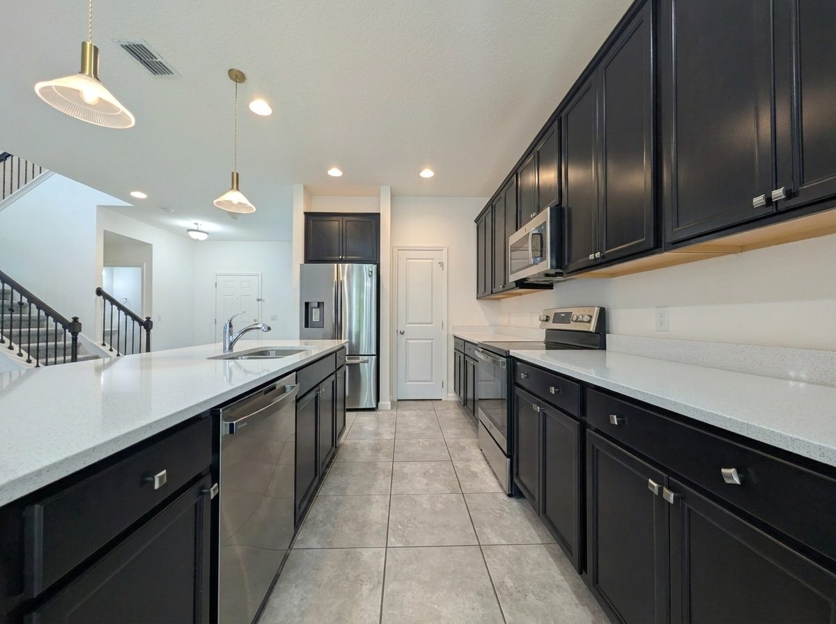 Kitchen with a quartz center island, dark cabinetry, and pendant lighting at 2275 Abilia Aly, Apopka